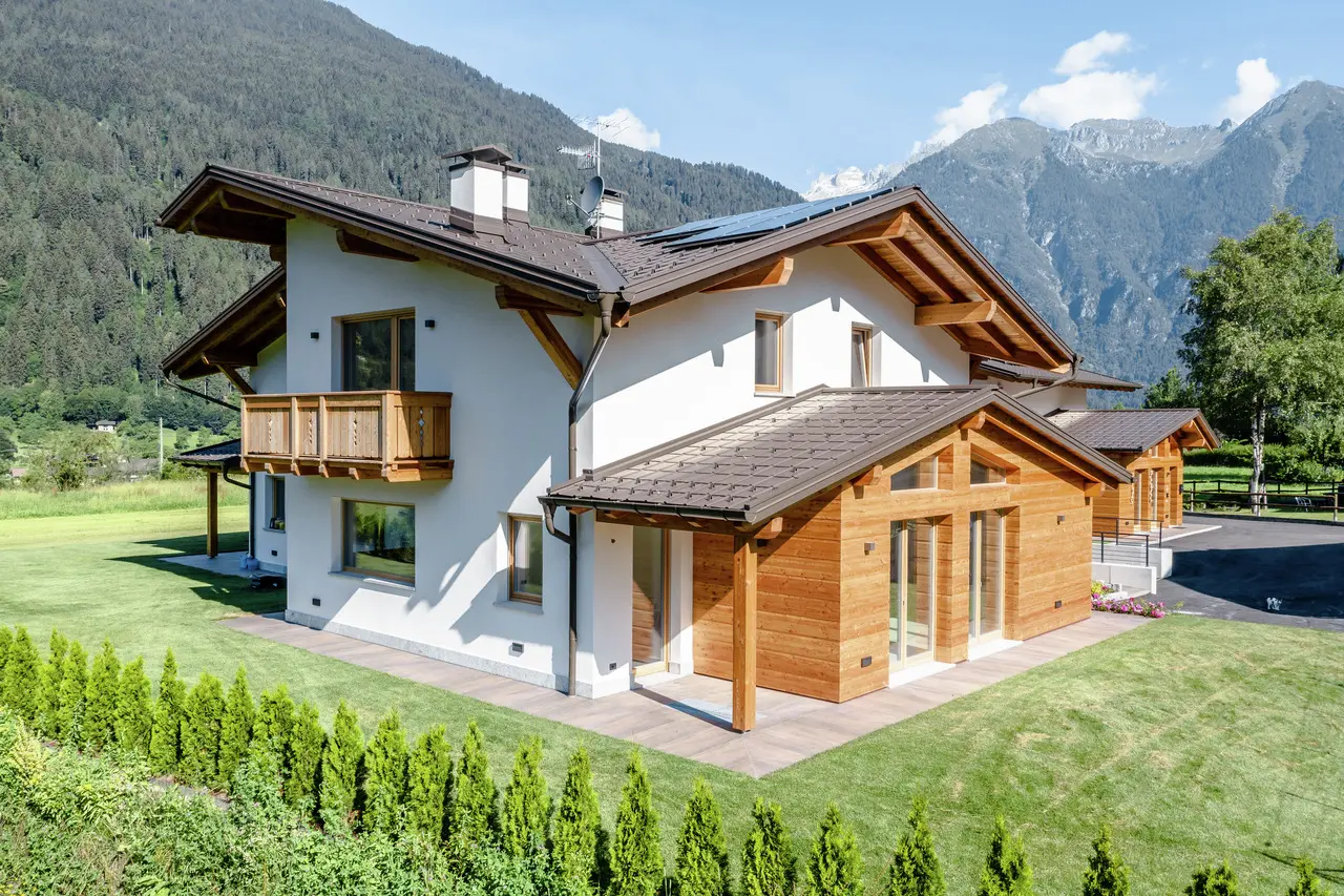 Traditionelles Wohnhaus in den Alpen mit brauner PREFA Hängerinne – langlebige Aluminium-Dachentwässerungslösung in harmonischer Farbabstimmung zur Holzfassade und Dacheindeckung.
